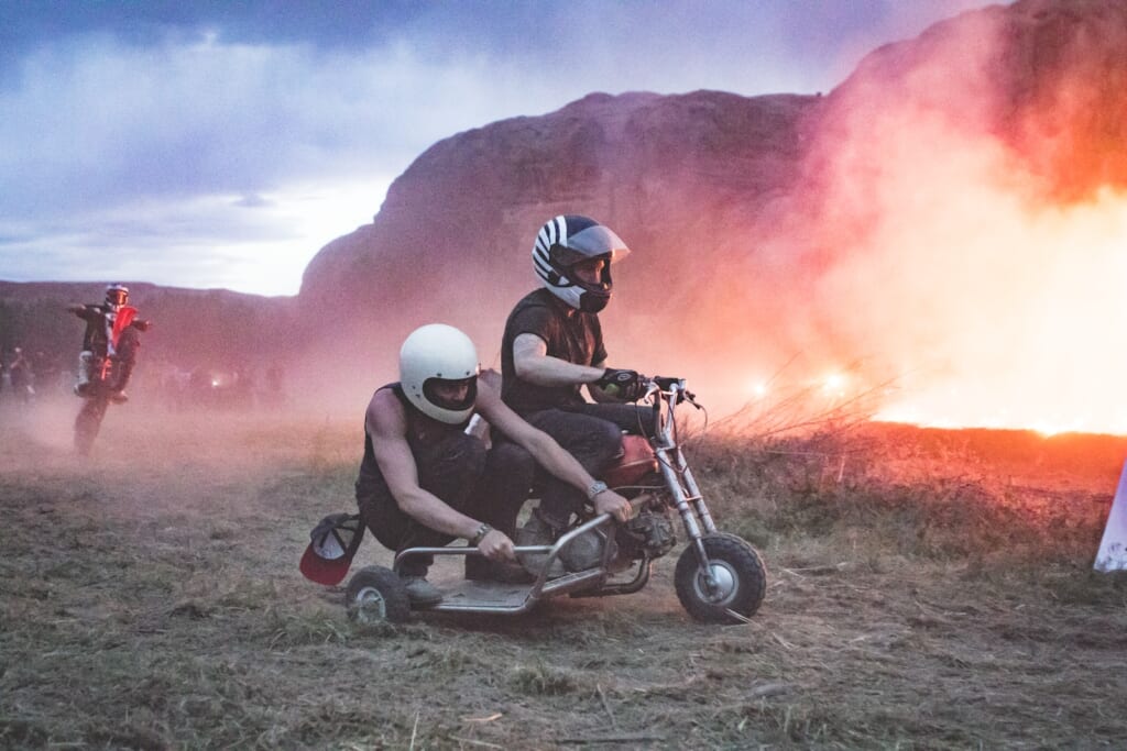 two men riding motorcycle with cart