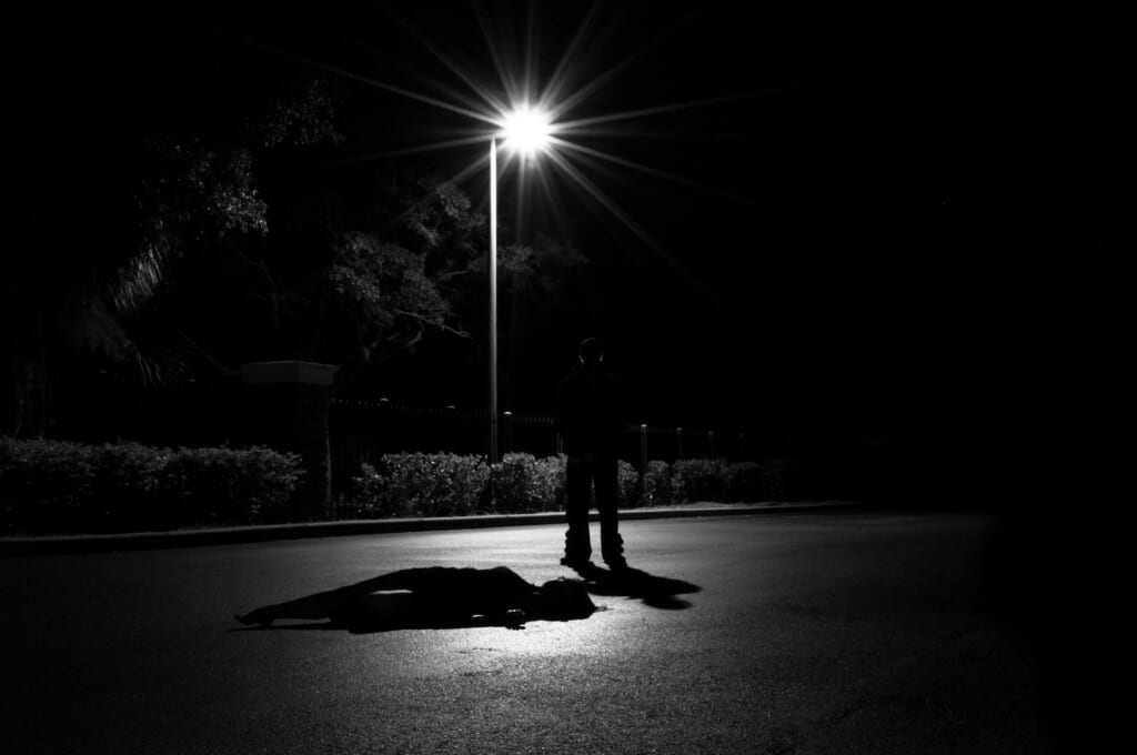 a person laying on the ground under a street light