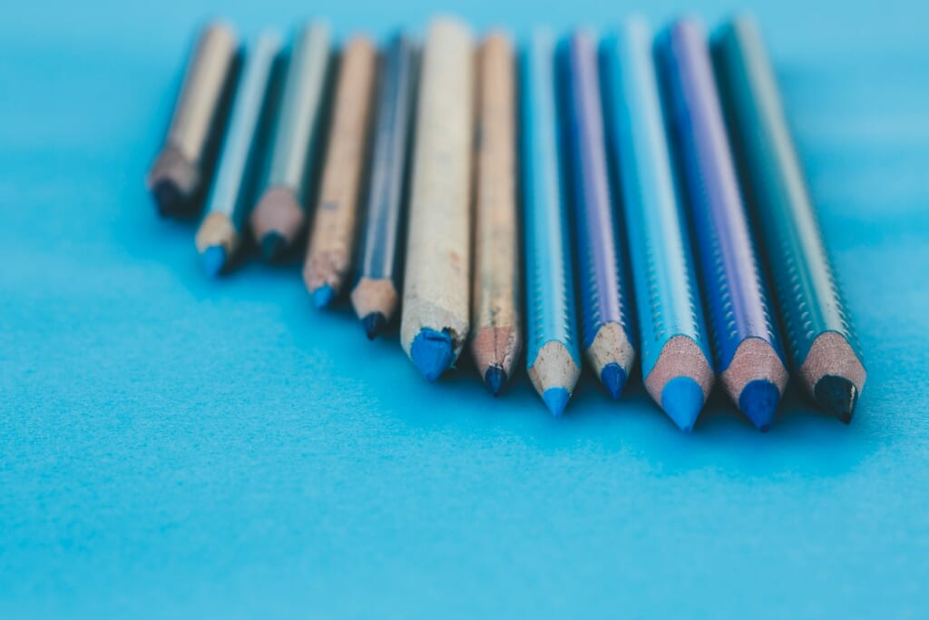 brown and gray pencils on teal surface