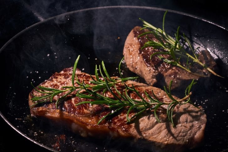 フライパンで肉を焼く写真