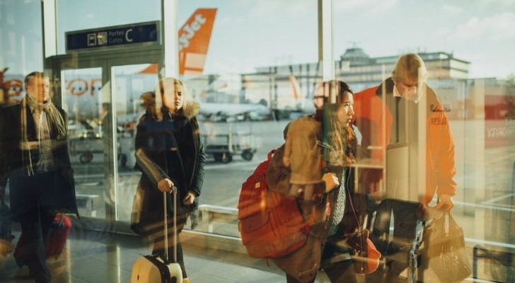 空港でスーツケースを持って歩く人々の画像