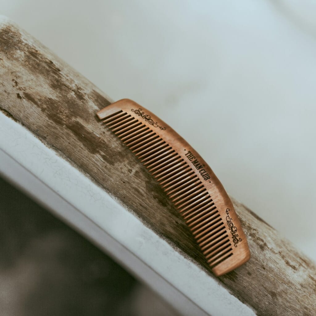 brown hair comb on white wooden table