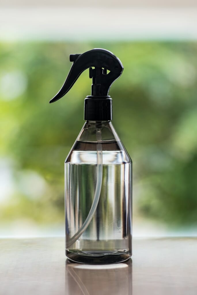 a spray bottle on a table with a blurry background