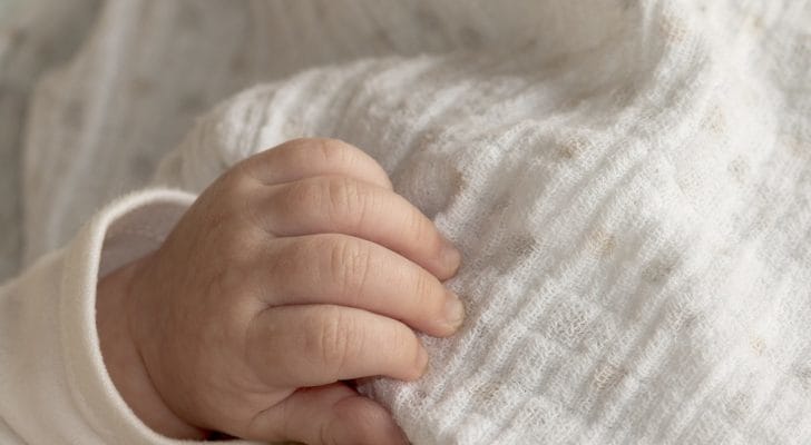 赤ちゃんがガーゼのブランケットをつかむ写真