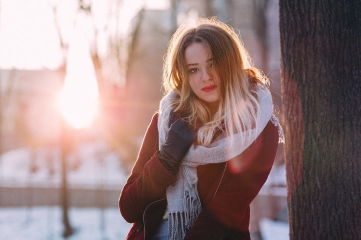 手袋とマフラーをした女性が立っている写真
