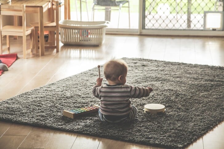 引き戸窓のある部屋で赤ちゃんが遊んでいる写真