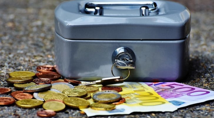 小型の金庫と硬貨の写真